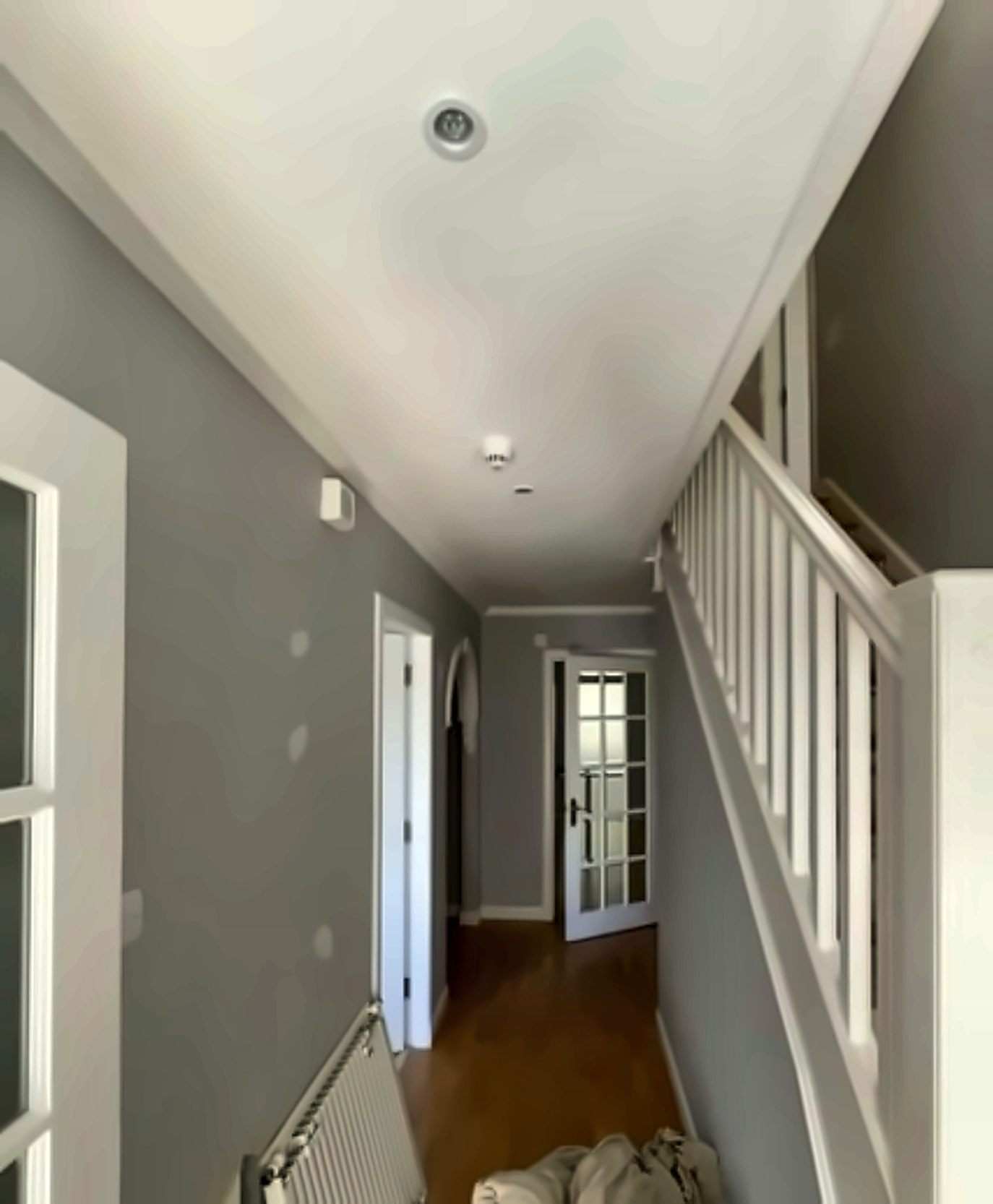 SE London hallway plaster repairs with filler patches on grey walls before the final skim.